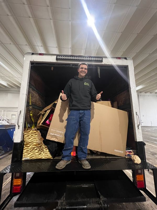Crew member giving a thumbs up from a box truck loaded during an estate cleanout by Classic Cleanouts